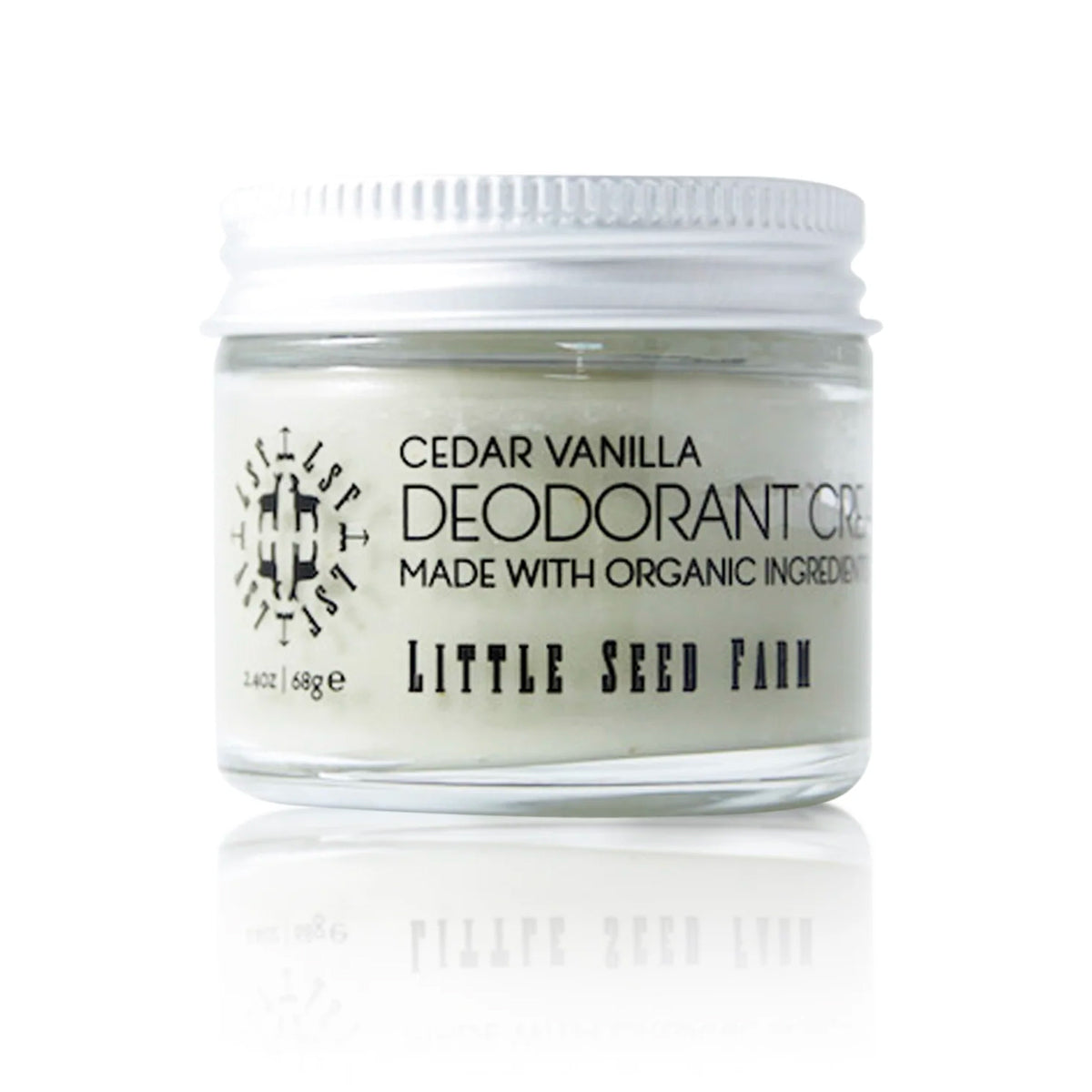 A jar of Little Seed Farm deodorant cream is shown on a white, reflective surface. The product is identified as "Cedar Vanilla" and is made with organic ingredients.
