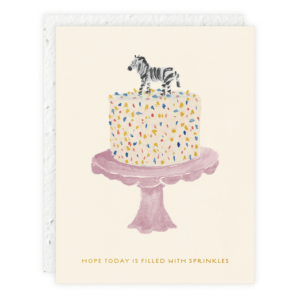 A seedling card showing a white cake with colorful sprinkles on a pink cake stand, topped with a small zebra figurine. Text reads: "Hope today is filled with sprinkles."