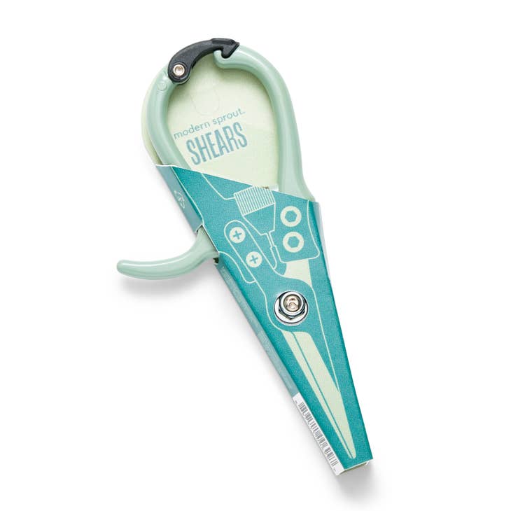 A pair of light green shears is shown in a teal-colored cardstock sleeve. The sleeve is branded with the name Modern Sprout and the product name Shears.
