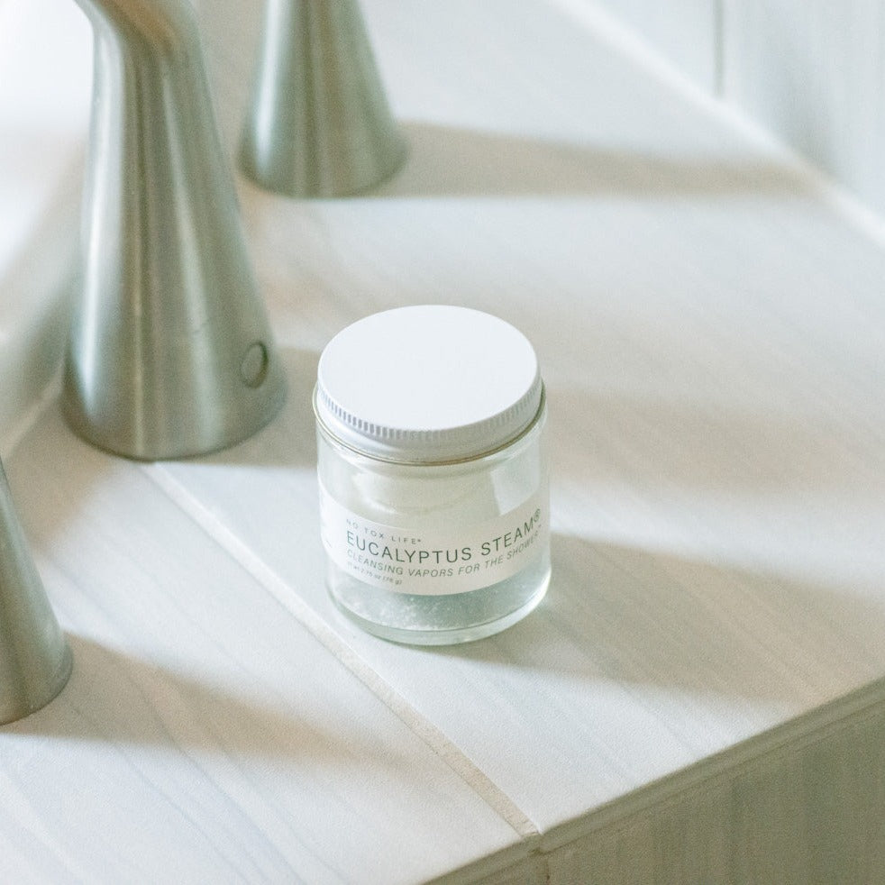 A shot of the "Eucalyptus Steam" jar tablets next to a hand sink, made to display the small and practical proportions of the product.