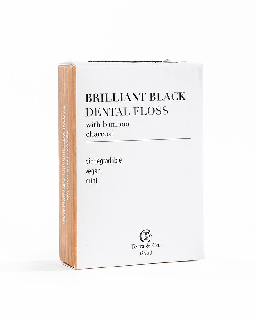 Brilliant Black bamboo charcoal dental floss white box on white background. Made with activated charcoal, bamboo fiber, coconut oil, and peppermint and spearmint essential oils. Eco-friendly and fluoride-free.