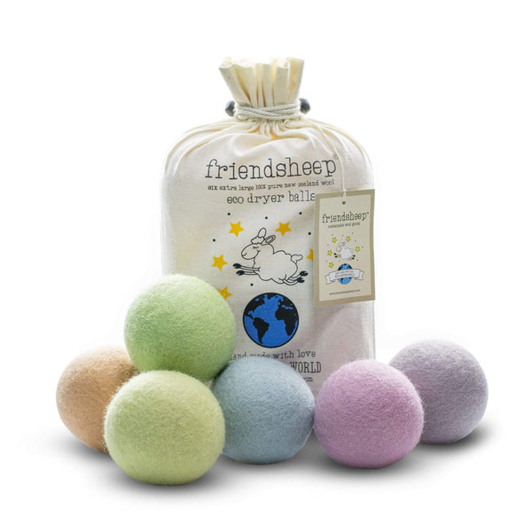 Close-up of 6-pack Friendsheep wool dryer balls with soft pastel tones and sheep-shaped decorations, shown alongside the natural cotton drawstring bag on a neutral background.
