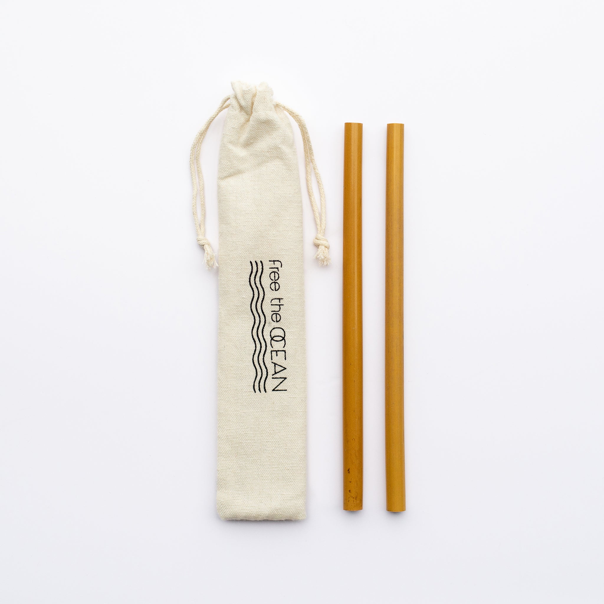 Two natural bamboo straws are shown alongside a beige fabric pouch with a "Free the OCEAN" logo, on a white background