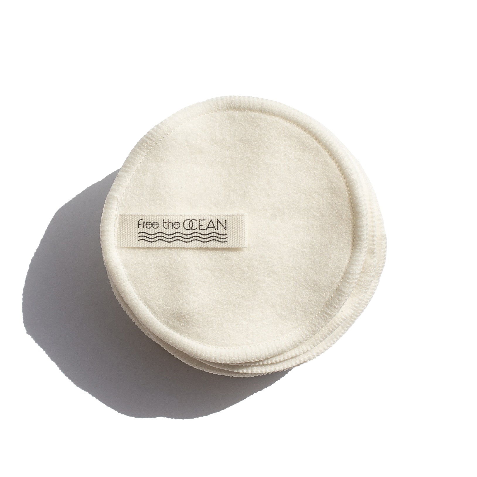 Set of 12 round reusable makeup remover pads neatly stacked on a white background, showcasing their soft, natural fabric texture.