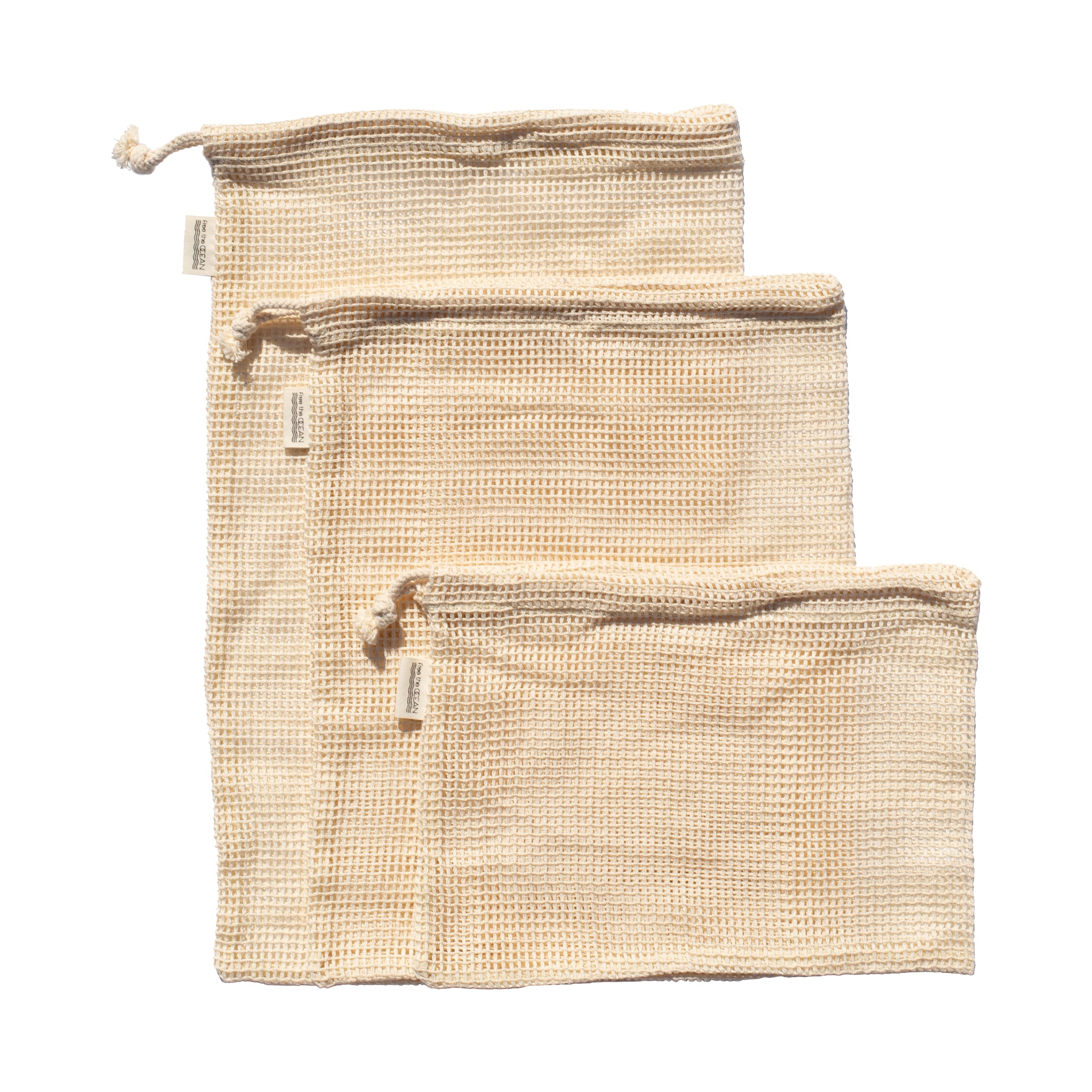 A set of three reusable produce bags is shown on a white background, arranged from largest to smallest. The bags are made of a natural-colored, waffle-textured fabric and feature a drawstring closure at the top.