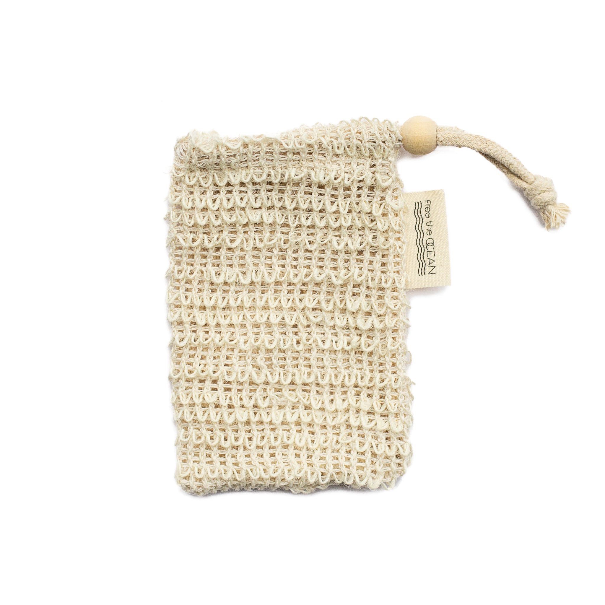 A single soap saver bag, made from a woven, light-colored natural material, lies on a white background. It has a drawstring with a bamboo bead and a "Free the OCEAN" tag