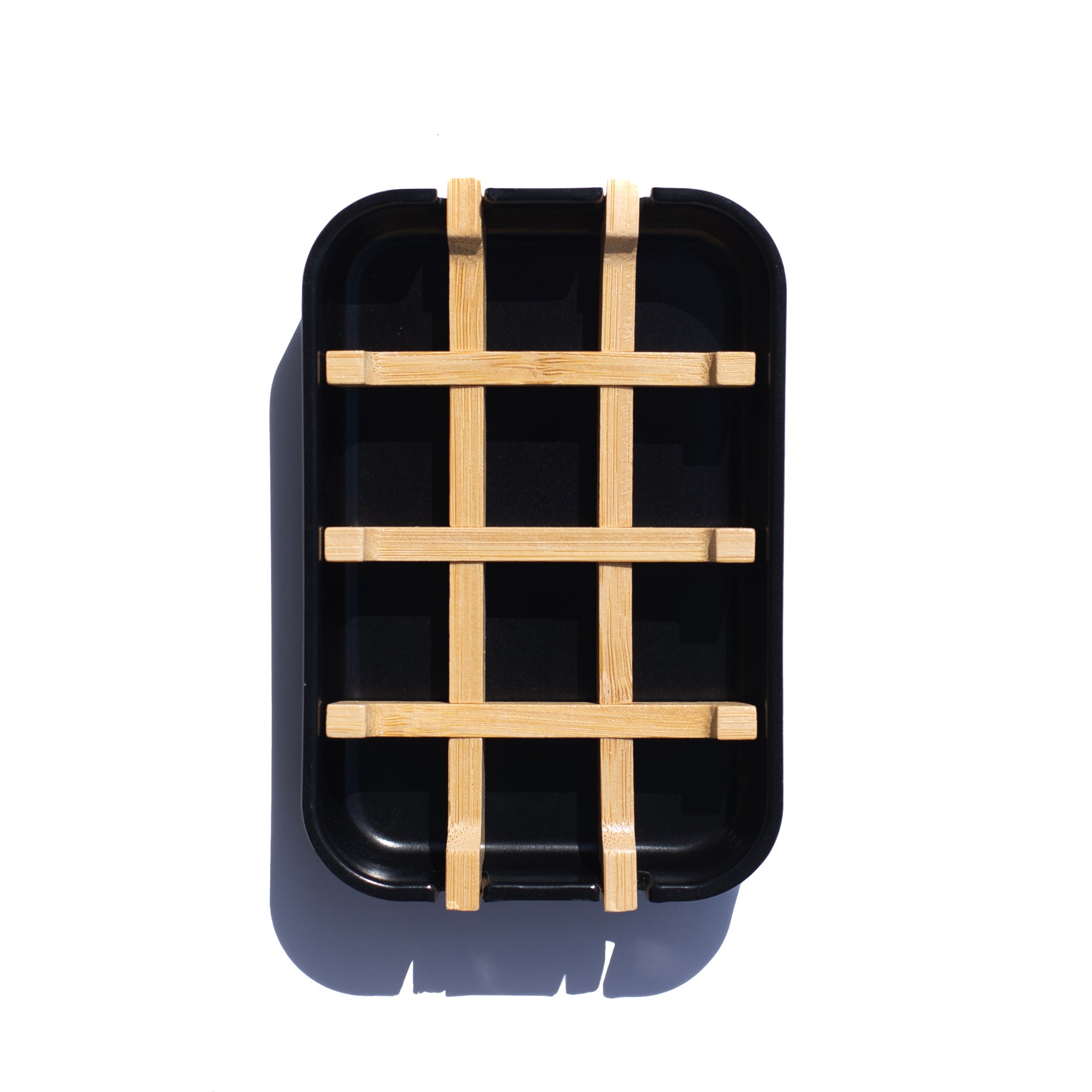 A top-down view of a rectangular, black soap dish with a slatted bamboo insert, highlighting its minimalist design and functionality.