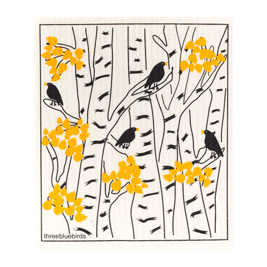Jet black blackbirds perch on black branches with yelow leaves on this reusable dishcloth, designed for effective cleaning with your chosen method.