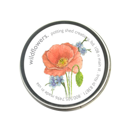 A silver tin of garden sprinkles with a white label featuring a watercolor illustration of a large red poppy and small blue wildflowers. The label text around the edge reads "wildflowers, potting shed creations"