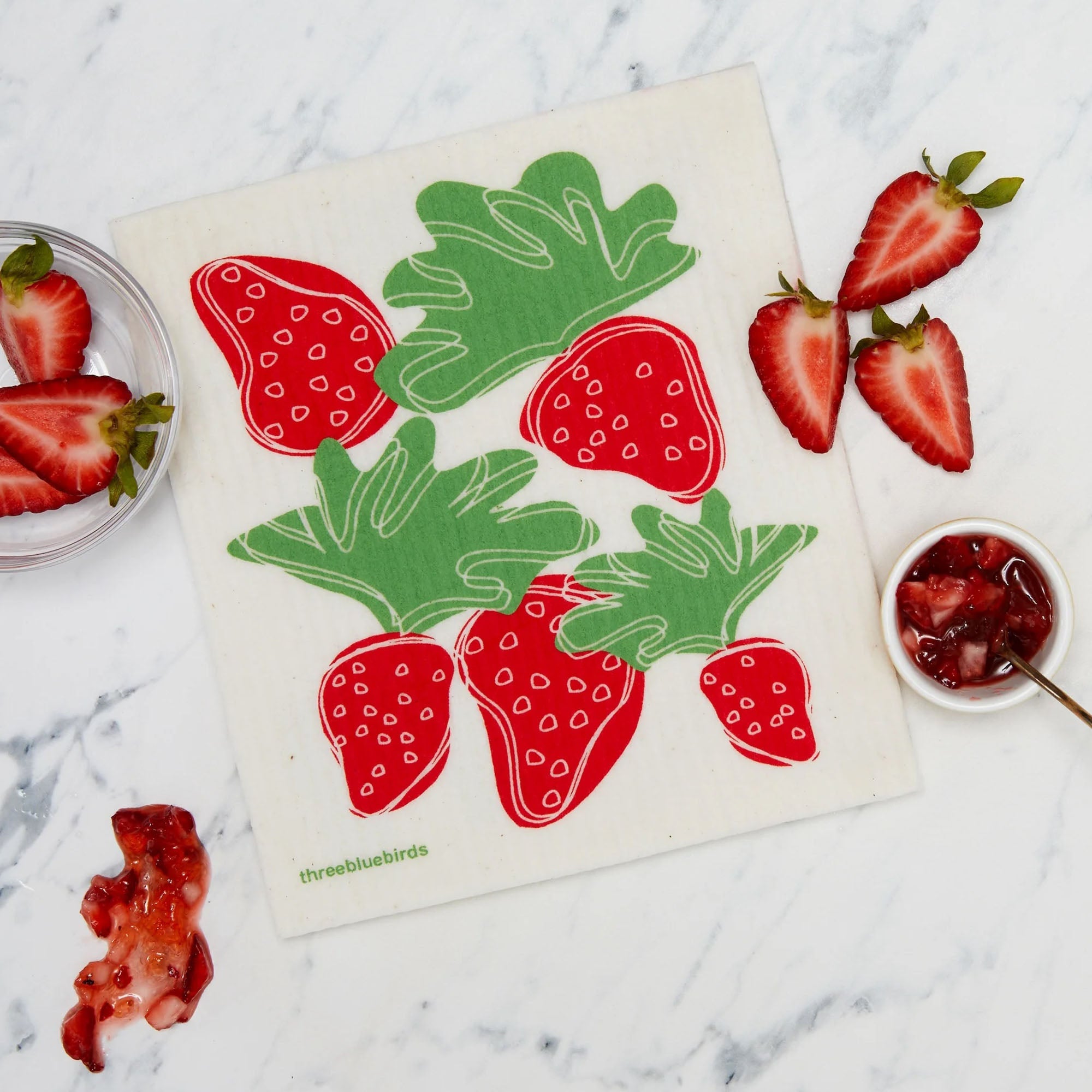A lifestyle image featuring reusable Swedish dishcloths with red strawberries 