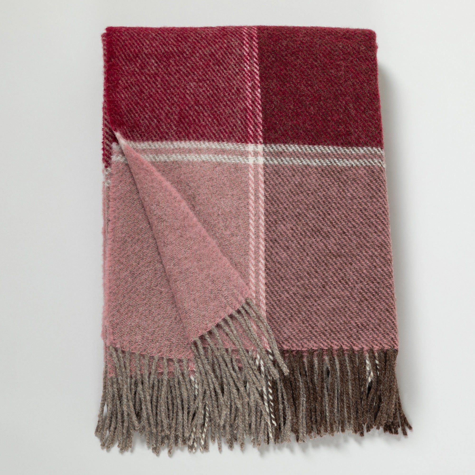 Ukrainian 100% wool fringed throw blanket in a burgundy, pink, and gray color block pattern, folded neatly with gray fringe edges