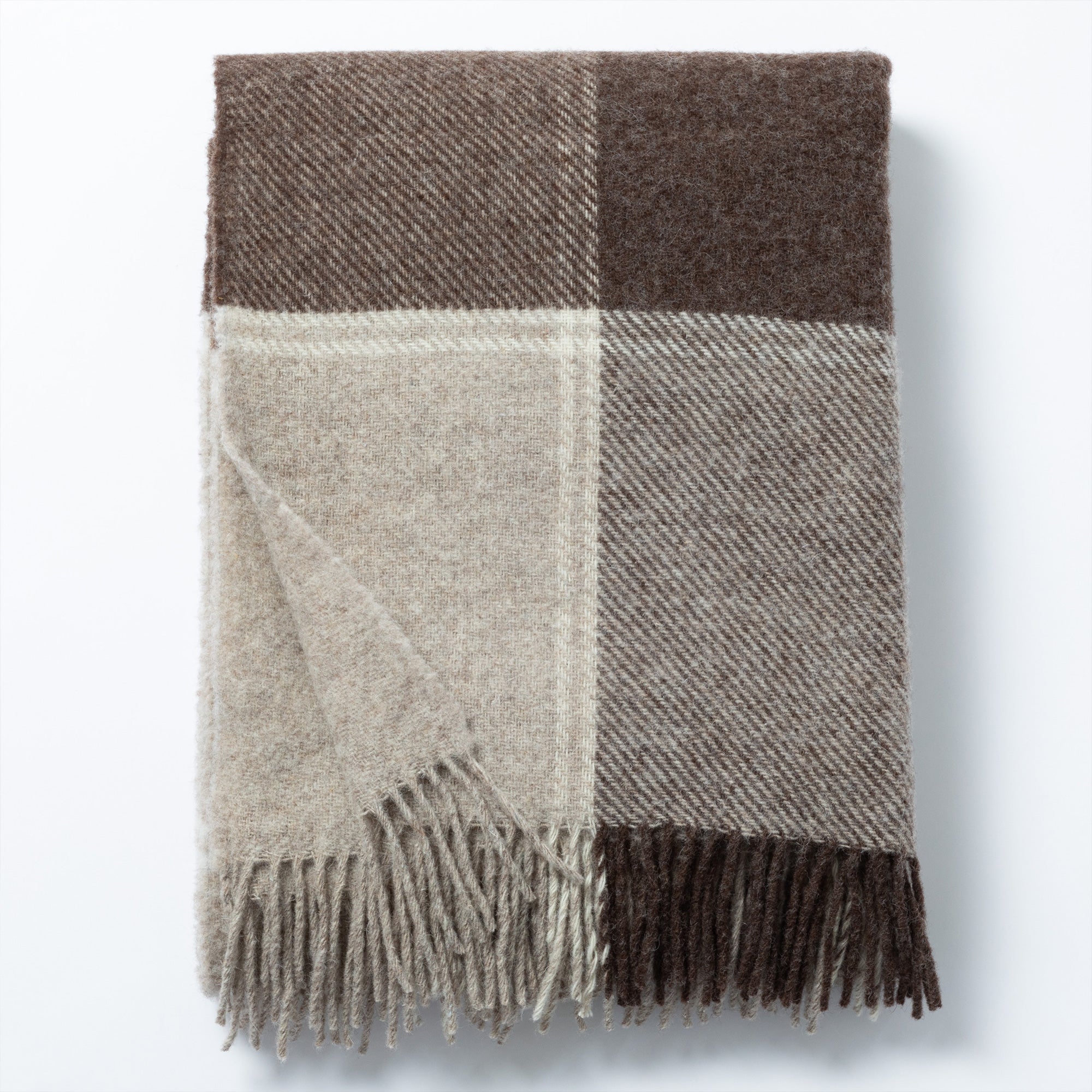 Folded 100% wool throw blanket in a neutral colorblock design with fringe, showcasing soft textures. Handwoven by artisans in Ukraine.