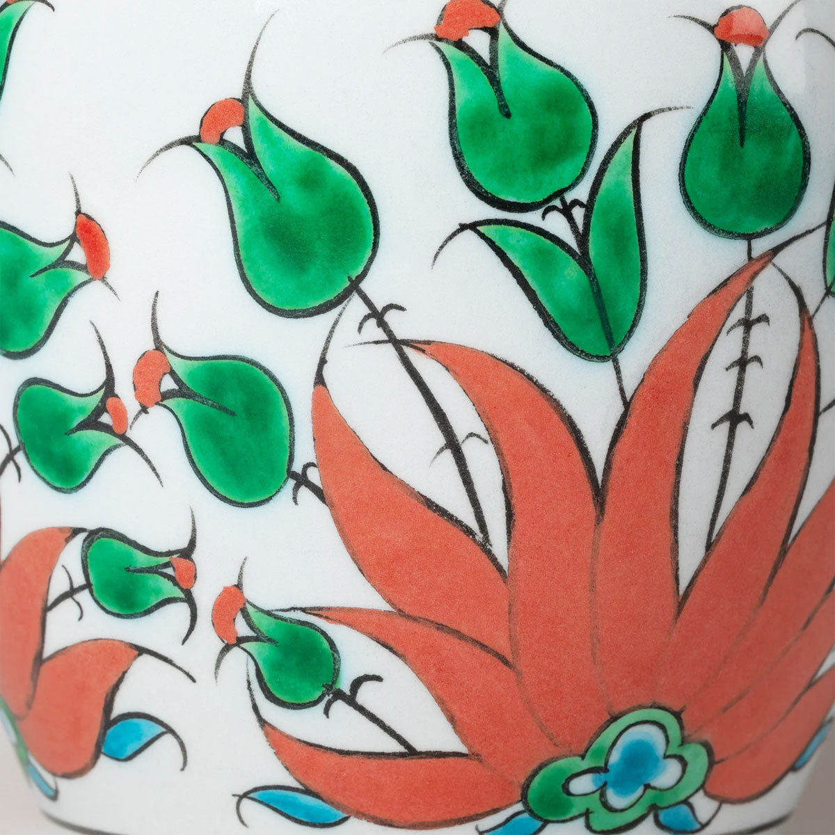 Decorative tile with orange and green floral patterns on a white background