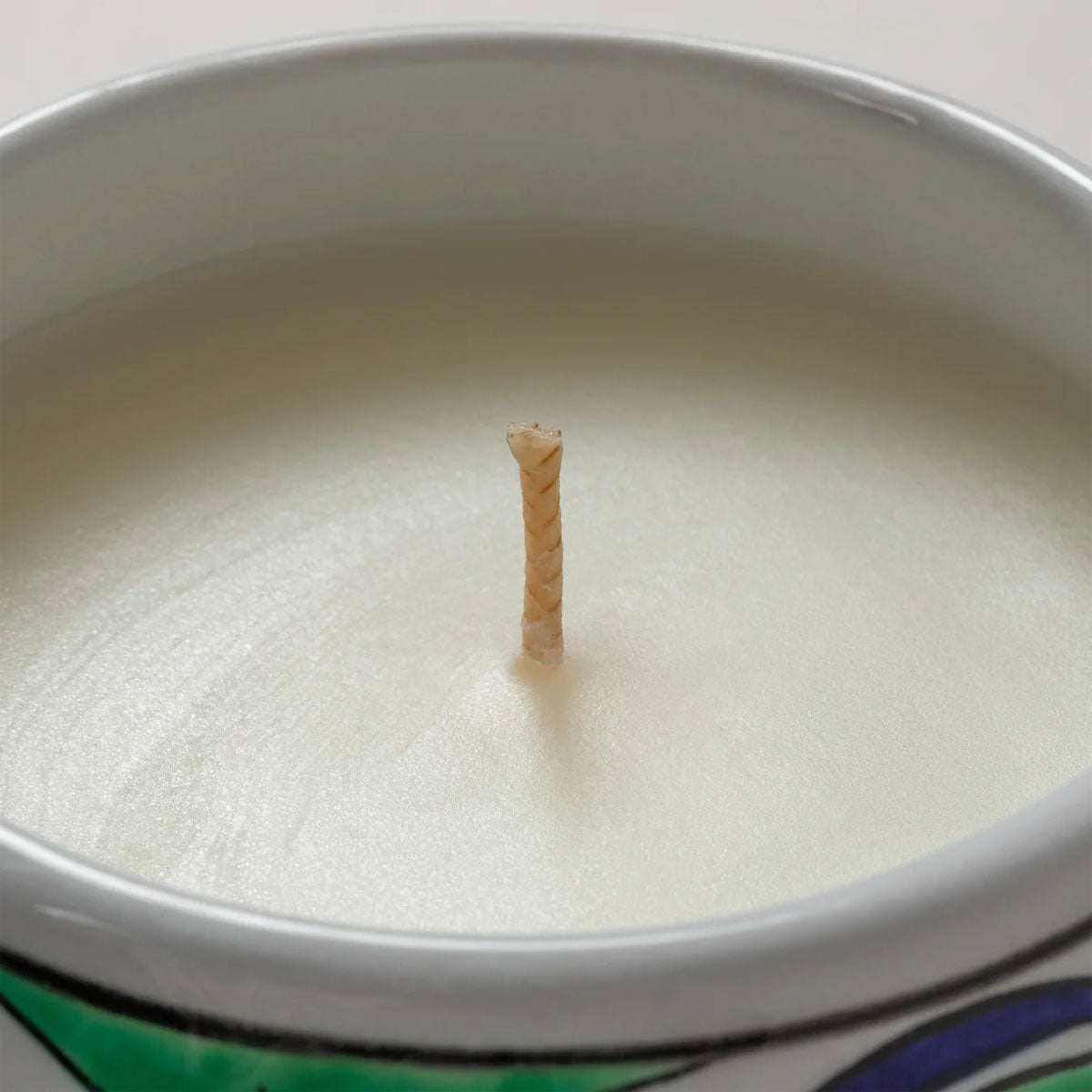 Close-up of a candle with a wick in a white container