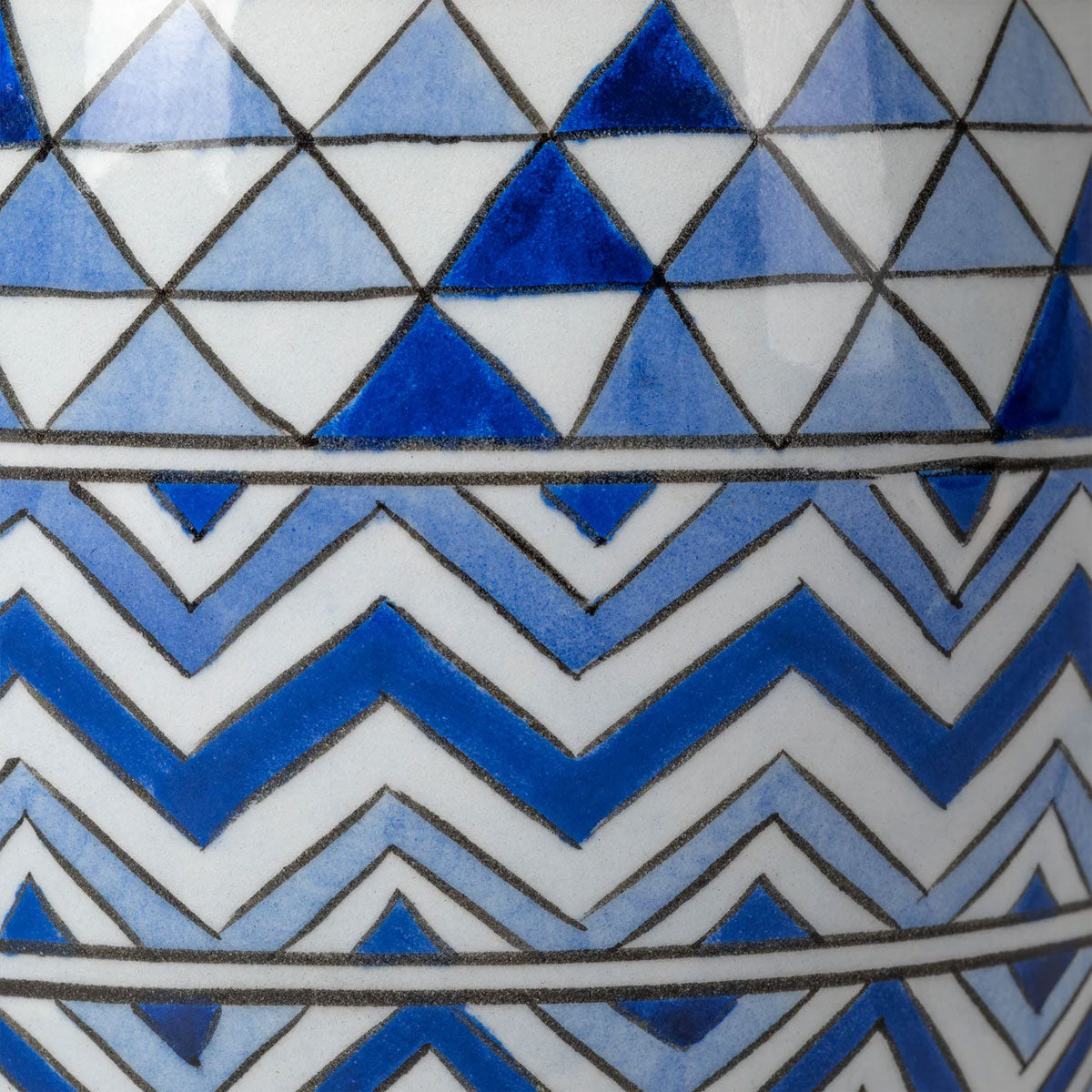Close-up of a geometric pattern with blue, white, and black triangles and zigzags.