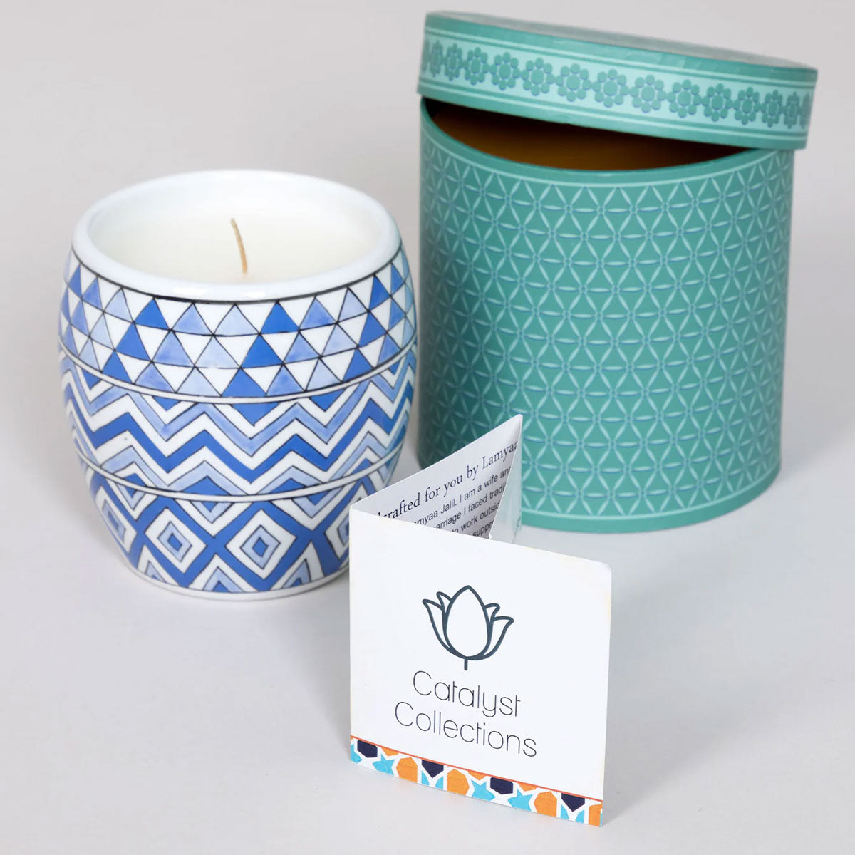 Candle with geometric pattern and teal container on a white background, featuring 'Catalyst Collections' card.