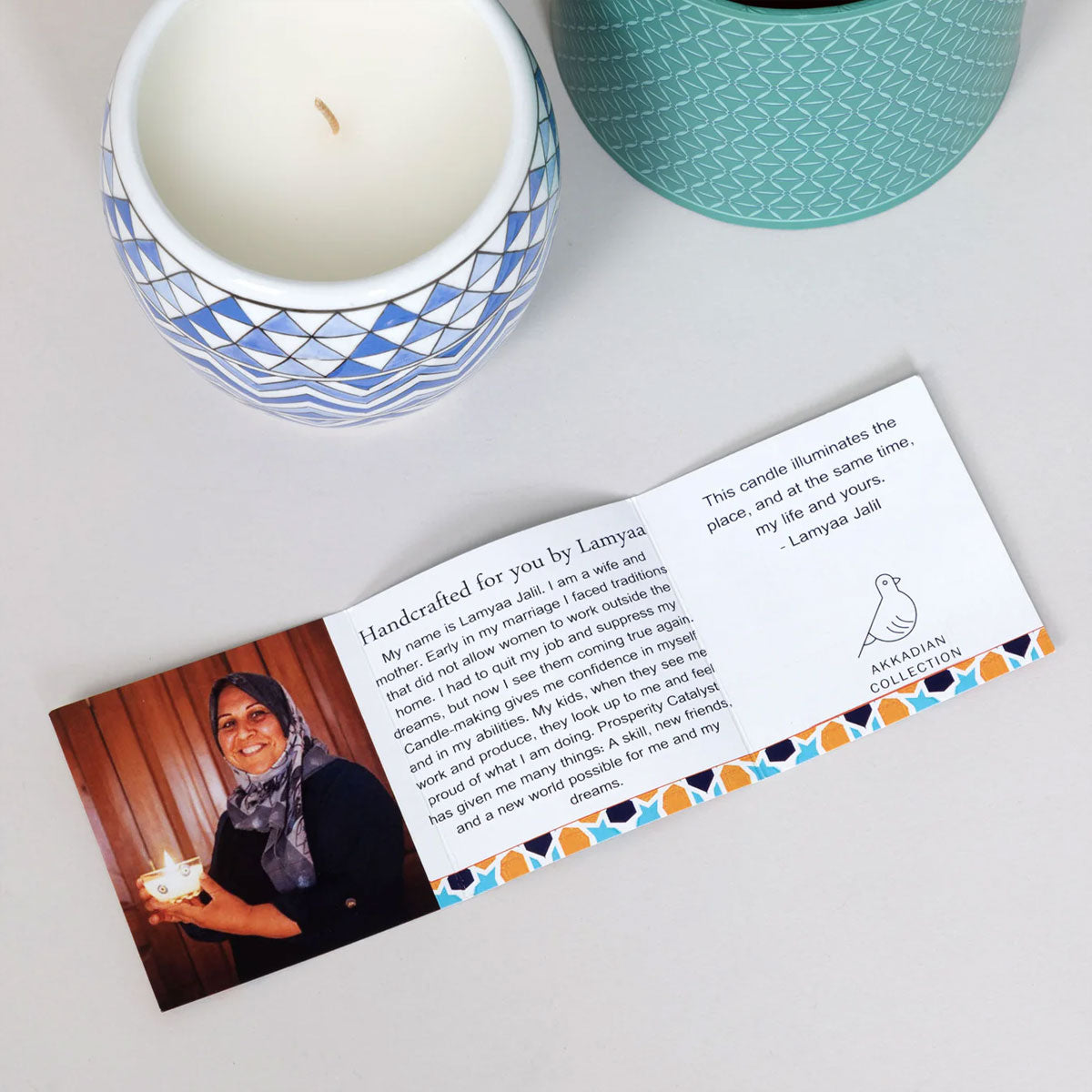 Candle with a personalized card featuring a photo and text on a white surface