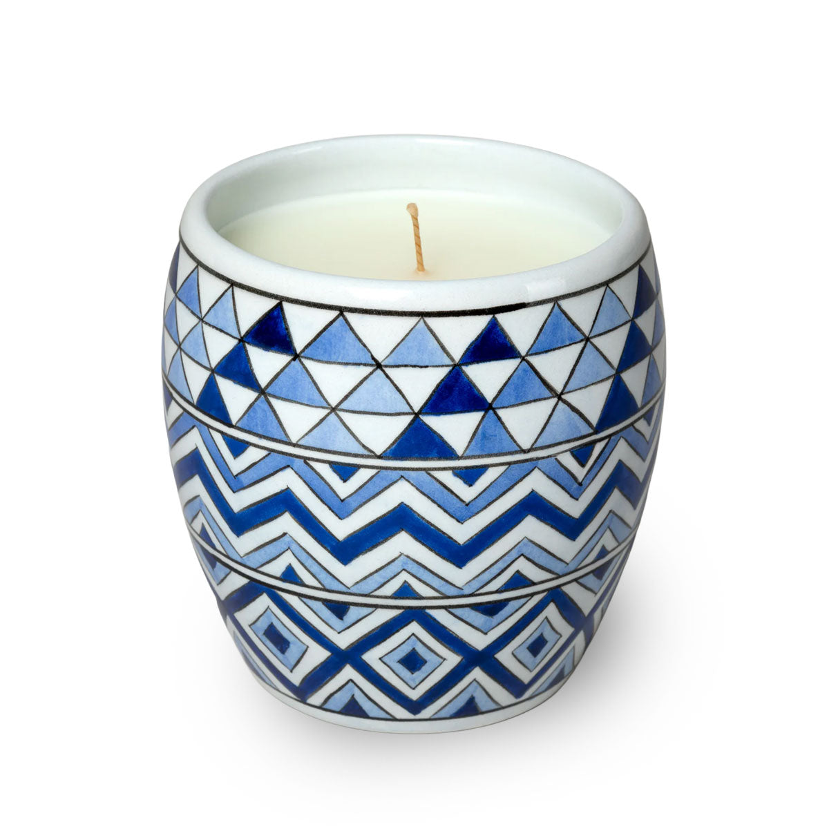 Candle in a blue and white geometric patterned container on a white background