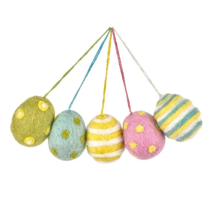 The image shows a set of five handmade felt Easter egg decorations, each with a different color scheme and pattern. They are hanging from strings and include designs with stripes and polka dots.
