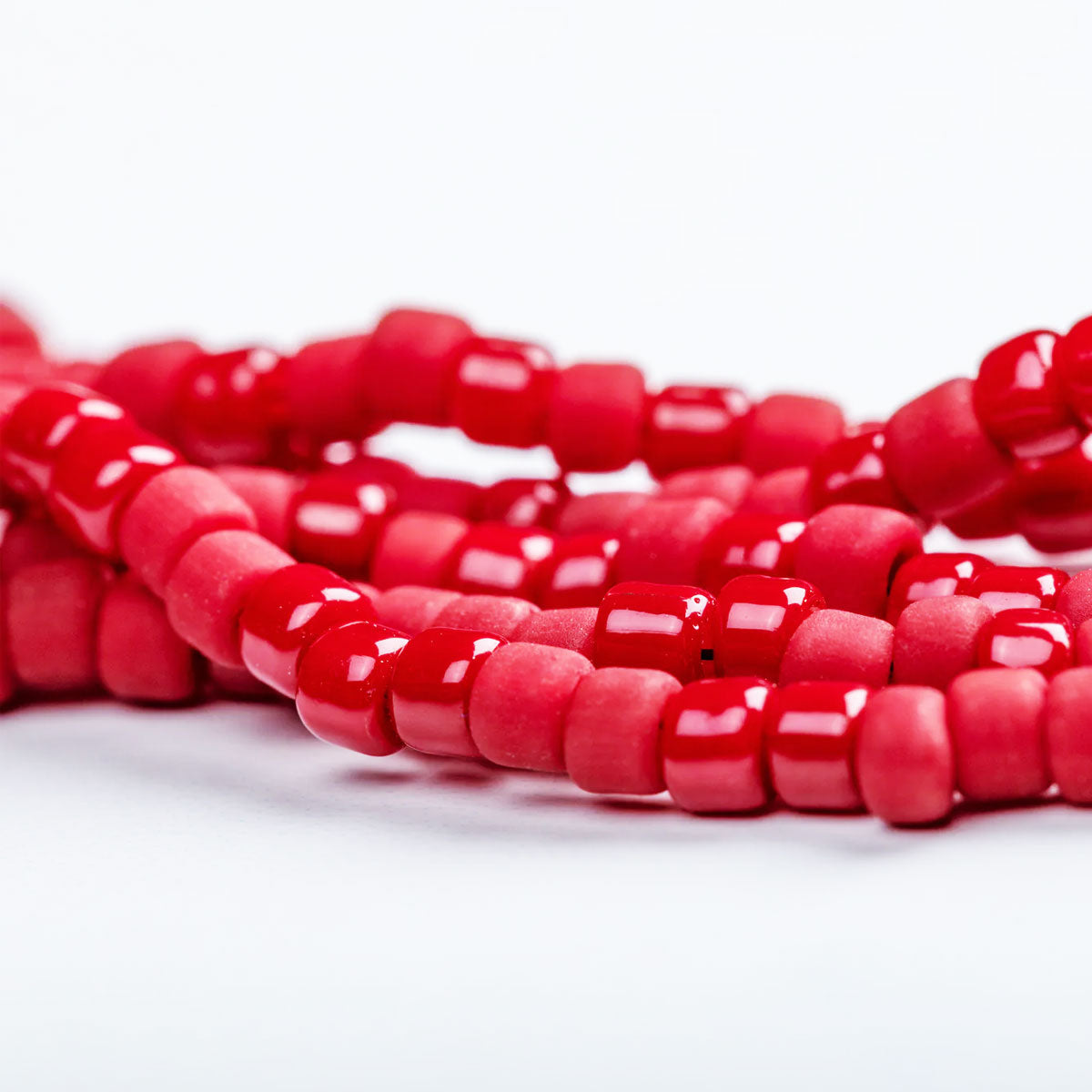 Close-up of red beads on a white background