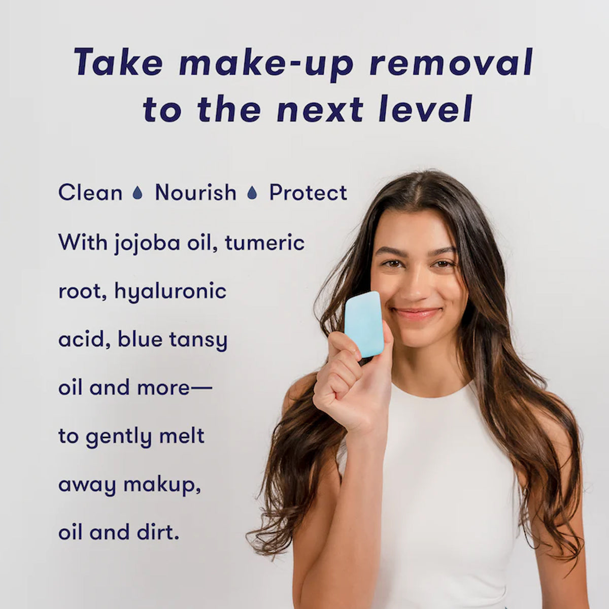 Woman holding a Solid Oil Cleanser makeup removal pad with text about product benefits on a light background