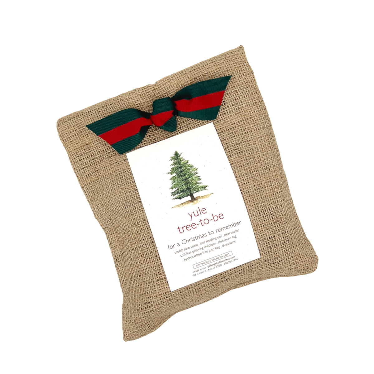 A "garden in a bag" burlap sack is tied with a festive red and green ribbon, with a card on top that says "yule tree to be" for a Christmas to remember. The card also mentions the contents include scotch pine seeds and a coir seeding pot.