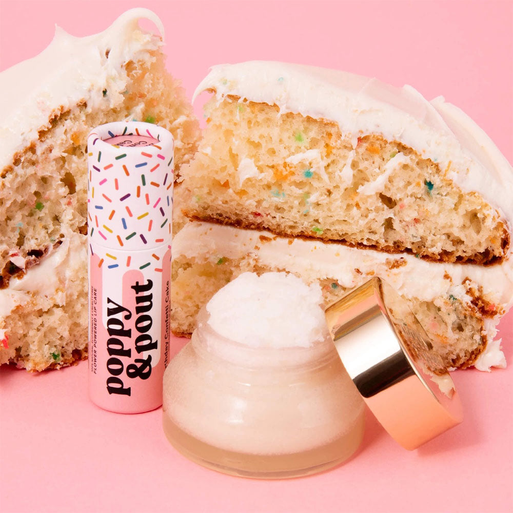 Lip balm with 'Poppy & Pout' branding next to a slice of cake on a pink background