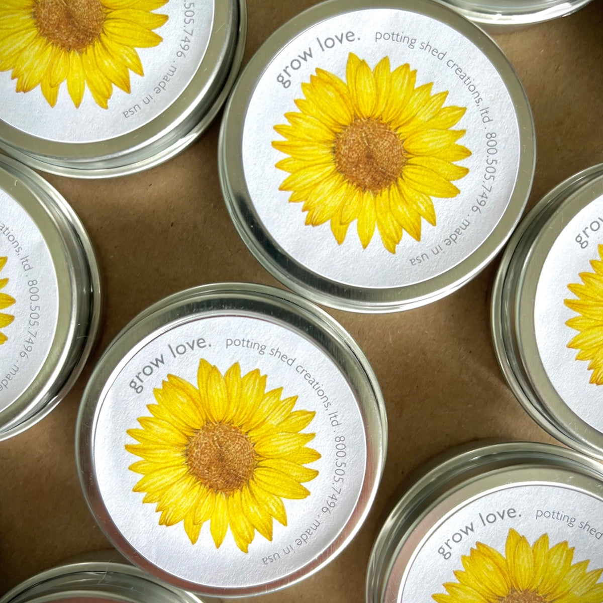 Jars with sunflower designs on lids and labels, arranged on a brown surface.