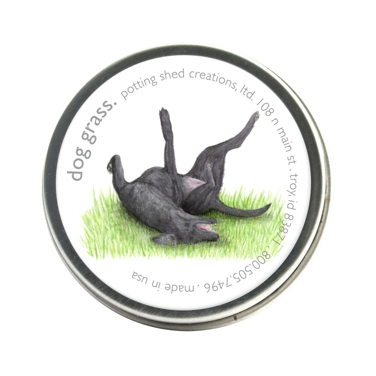 A silver tin of garden sprinkles with a white label on the lid. The label features a watercolor illustration of a black dog rolling playfully on its back in green grass, with the text 'dog grass, potting shed creations' around the edge.