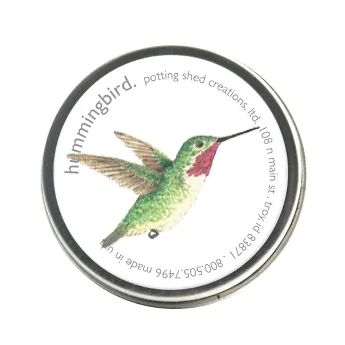 A silver tin ofgarden sprinkles with a white label on the lid. The label features a watercolor illustration of a green hummingbird in flight, with the text 'hummingbird, potting shed creations' around the edge.
