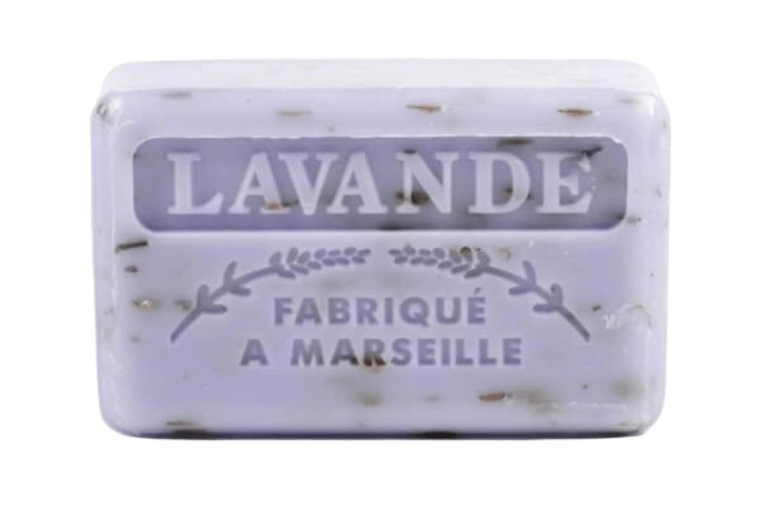 A lavender-colored French soap bar with embossed text reading "Lavande" and "Fabriqué a Marseille". It has dark specks.