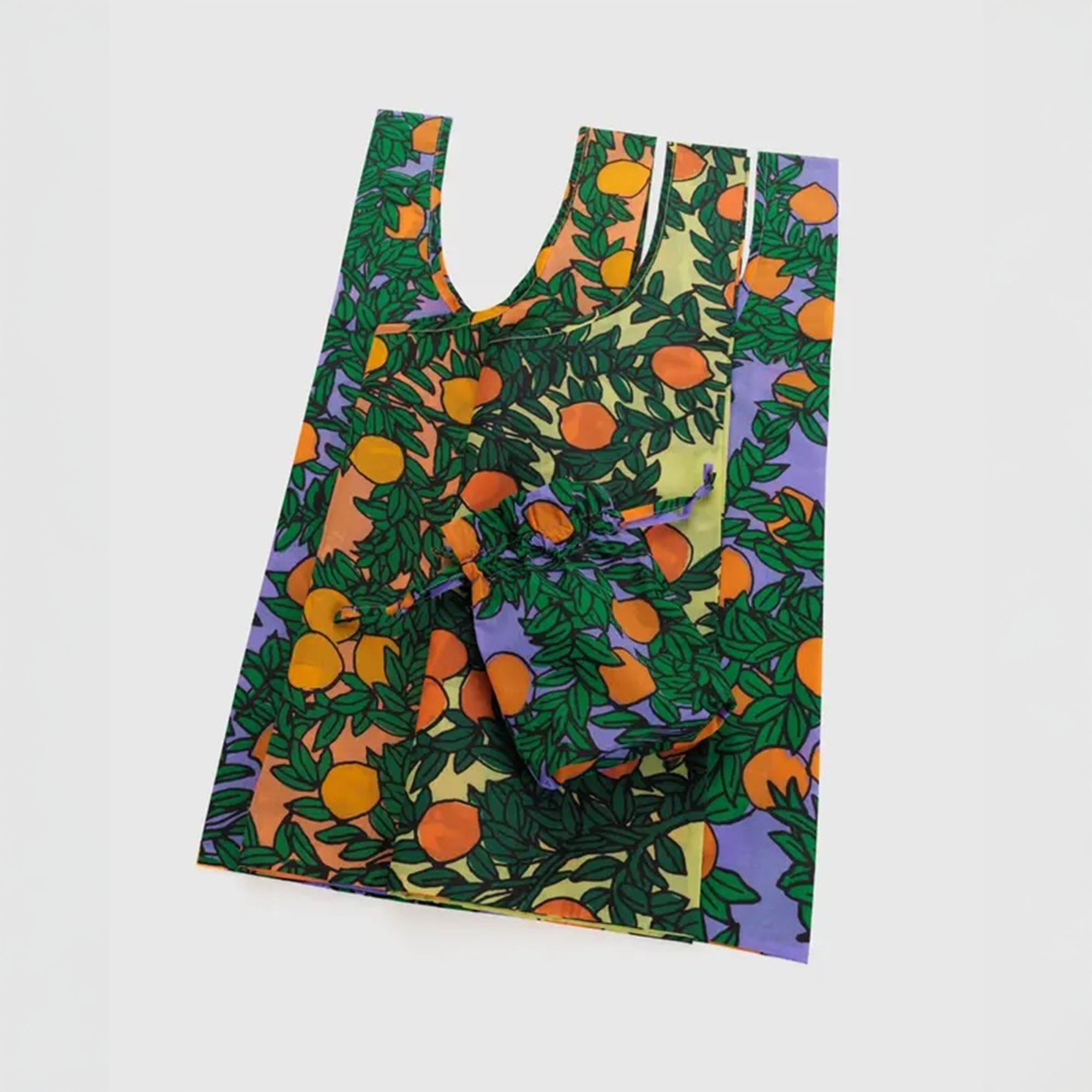 Flat lay of three BAGGU reusable bags in the “Orange Trees” set, displayed against a light background to highlight the citrus-inspired patterns and set variety.