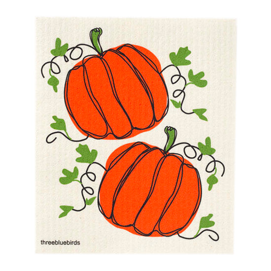 Two plump bright orange pumpkins paired with deep green leaves feature on this compostable reusable dishcloth