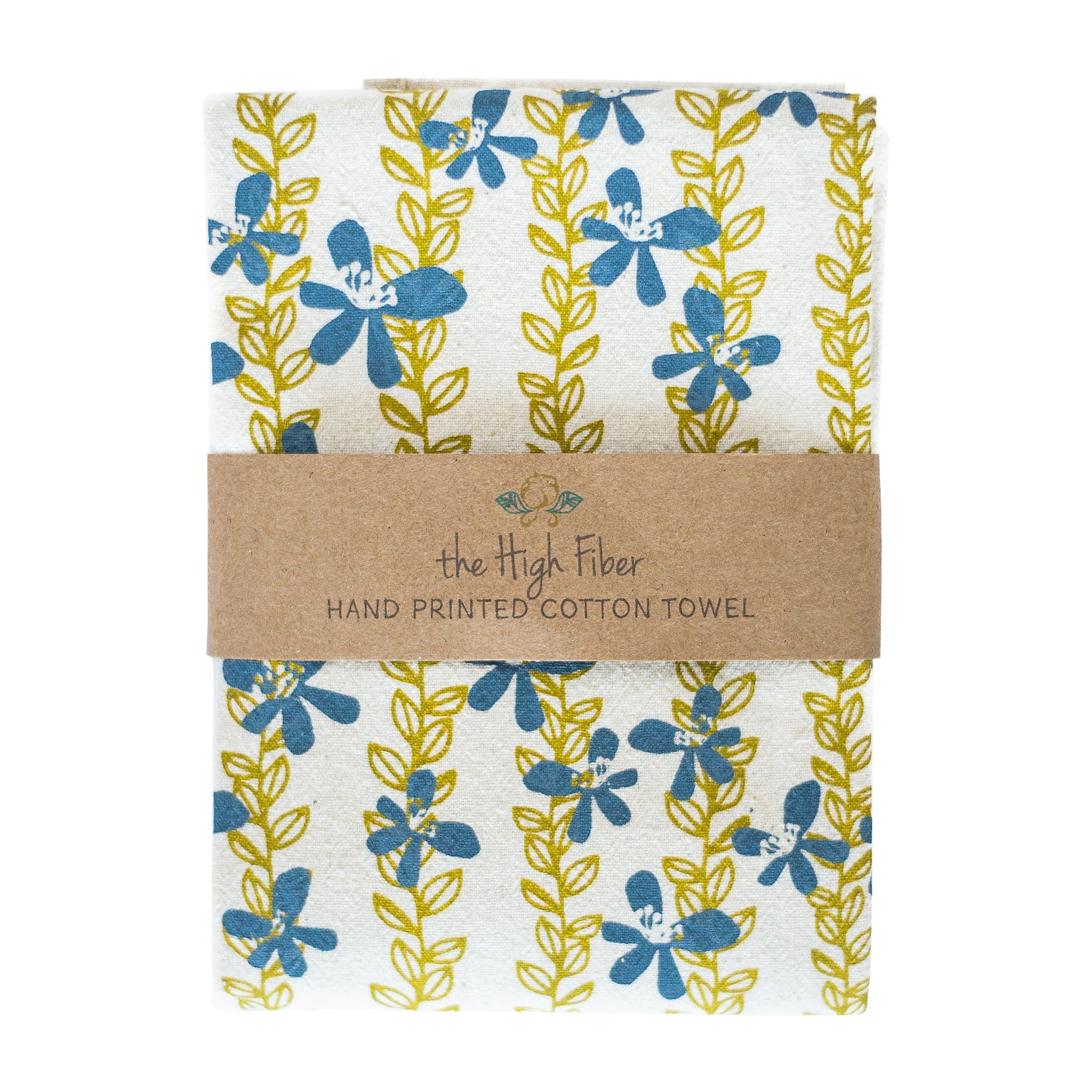 A hand-printed organic cotton tea towel from "the High Fiber," folded and wrapped with a brown band. It features a pattern of blue flowers on vertical yellow-green leafy vines.